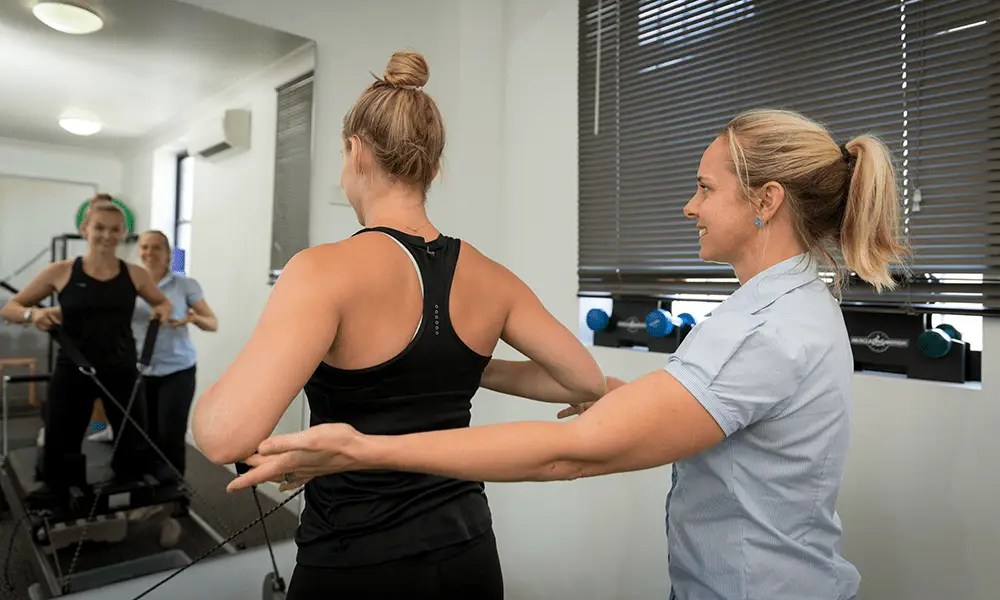 Mardi Watson during a reformer pilates session with a QSMC client