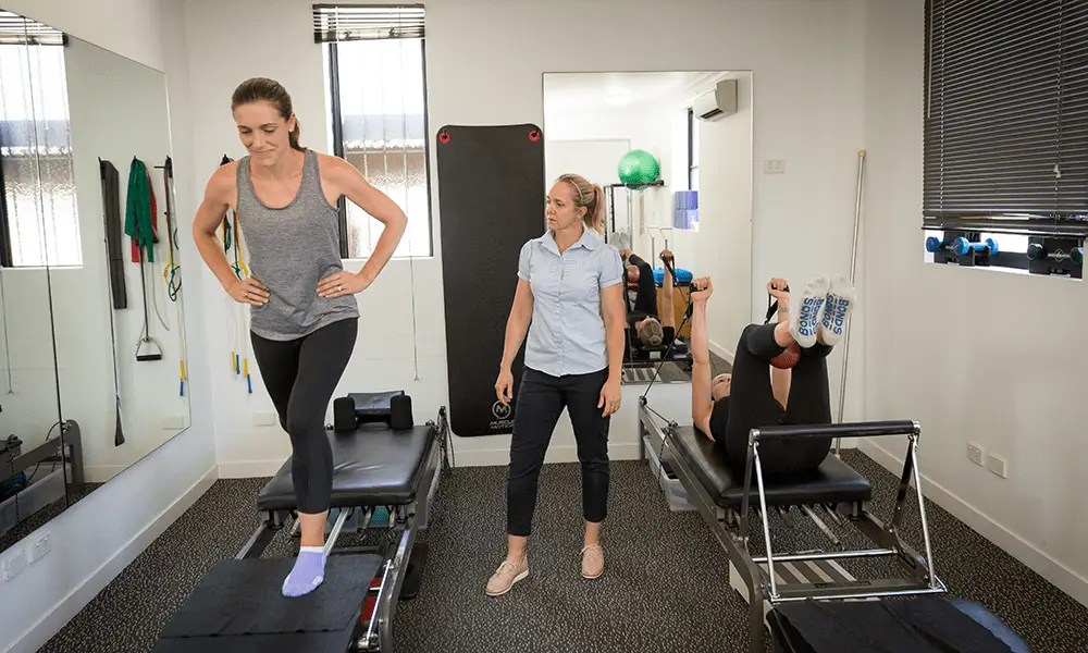 Two QSMC clients during a pilates session with Physiotherapist, Mardi Watson