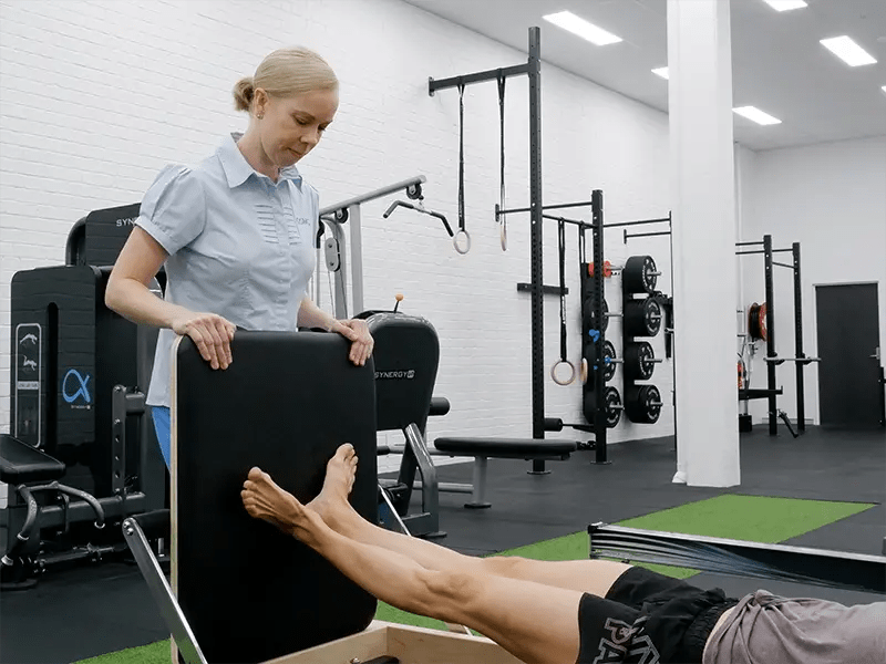 Melanie Fuller watching over a ballet dancer doing exercise on the reformer machine
