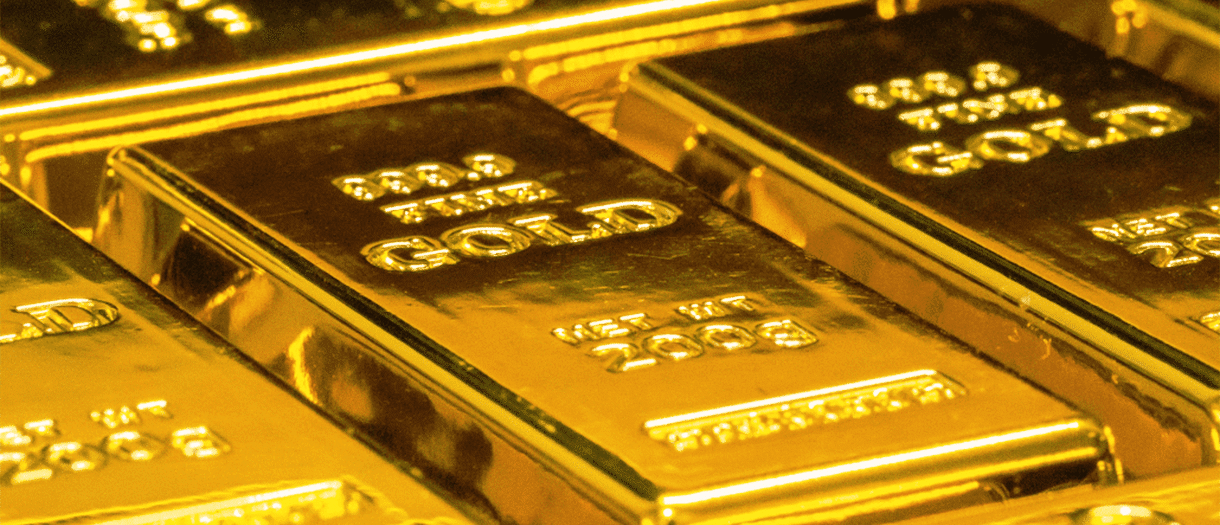 Close-up view of multiple stacked gold bars, each marked with weight and purity detai