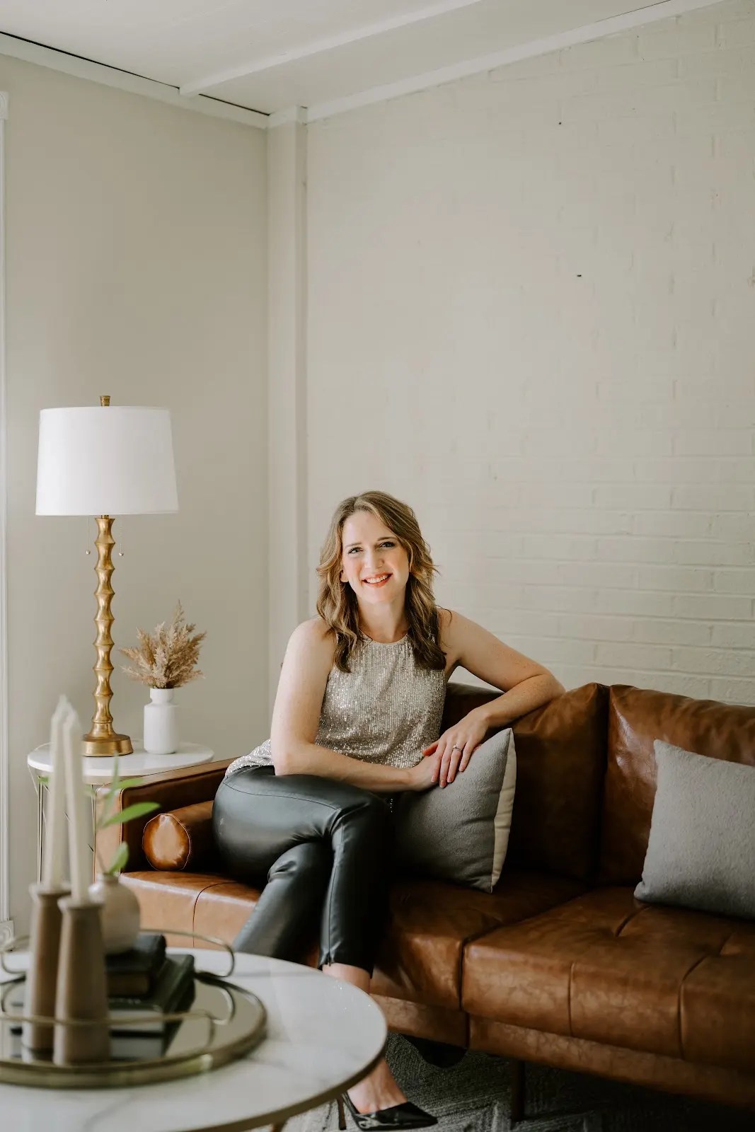 Rachel Ferrell seated on a leather sofa in a bright home