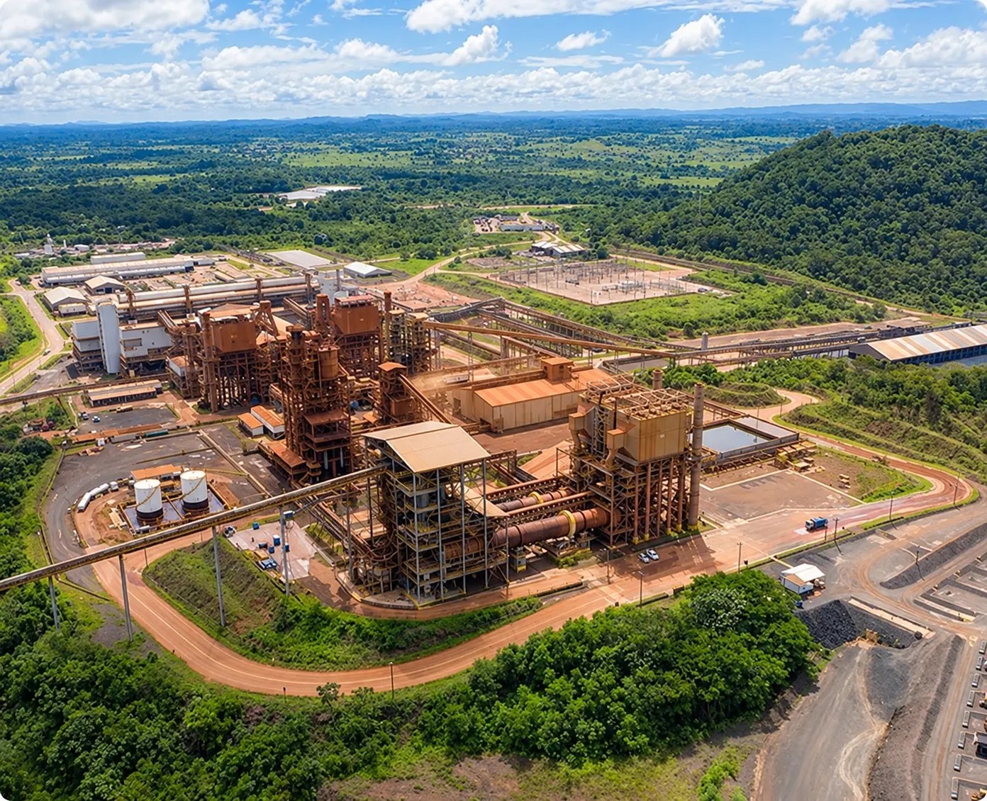 Vista aérea de uma grande instalação de mineração industrial da Vale Base Metals, cercada por florestas e colinas.