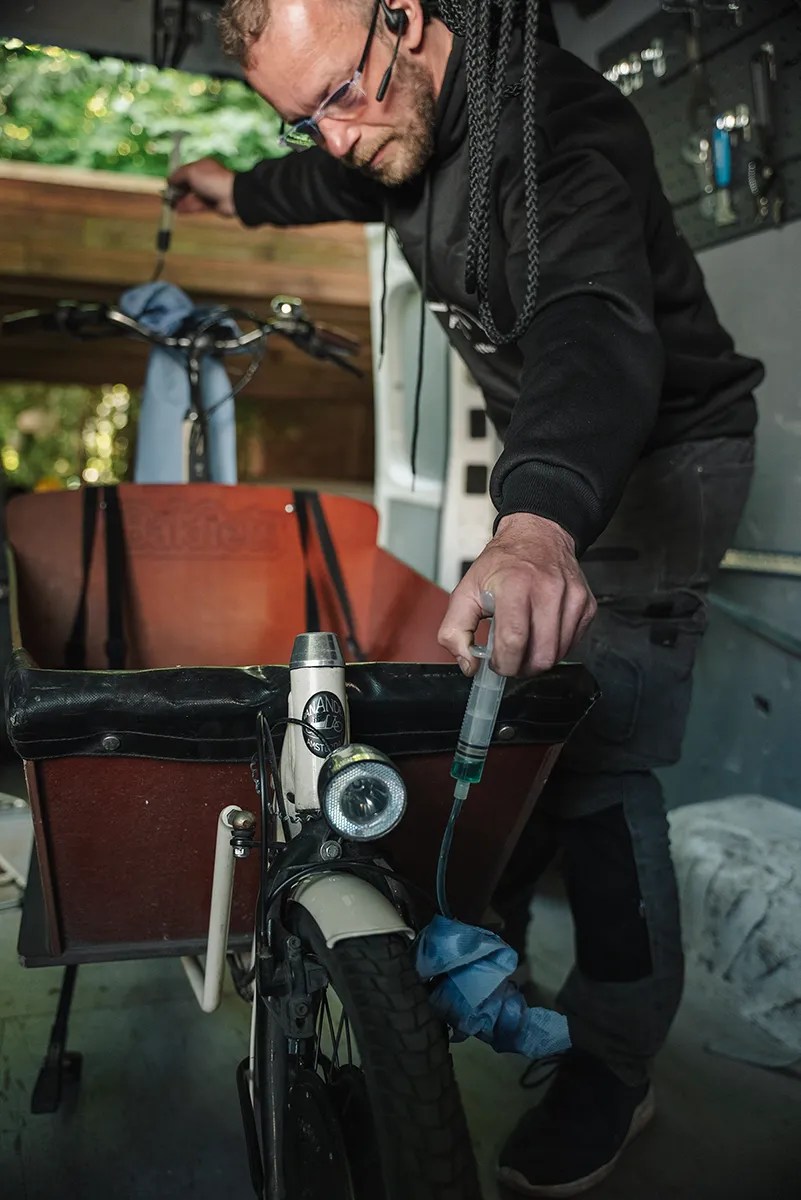 Fahrradmechaniker von Radblitz arbeitet an einem Lastenrad im Servicefahrzeug