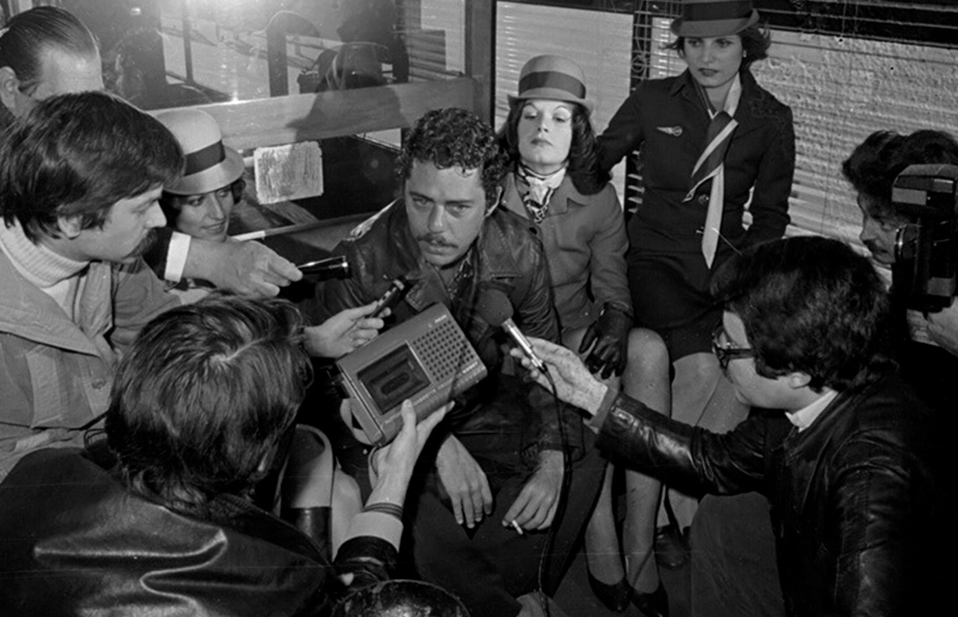 Chico Buarque dando entrevista para a imprensa no aeroporto de Lisboa