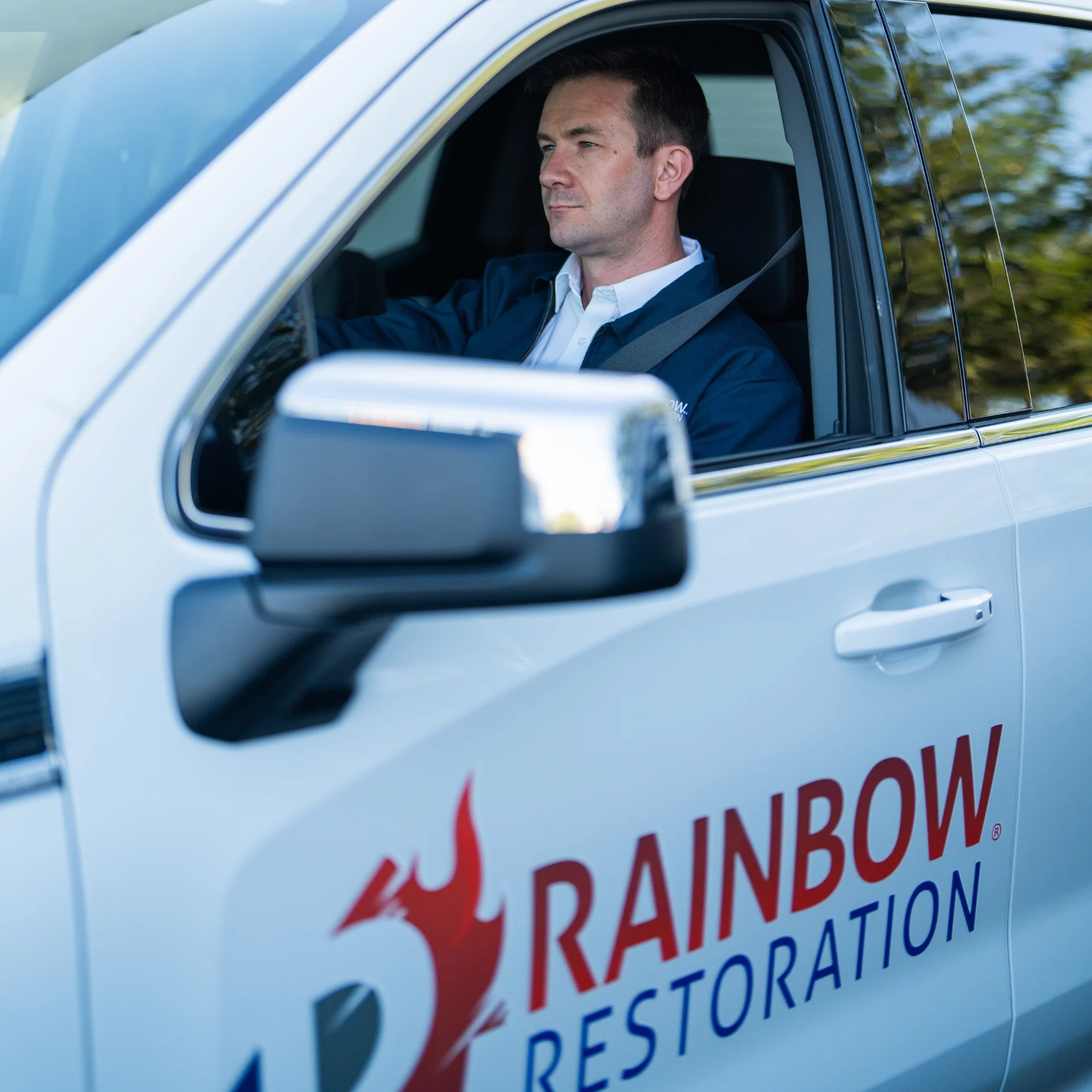 Team member in Rainbow Restoration vehicle