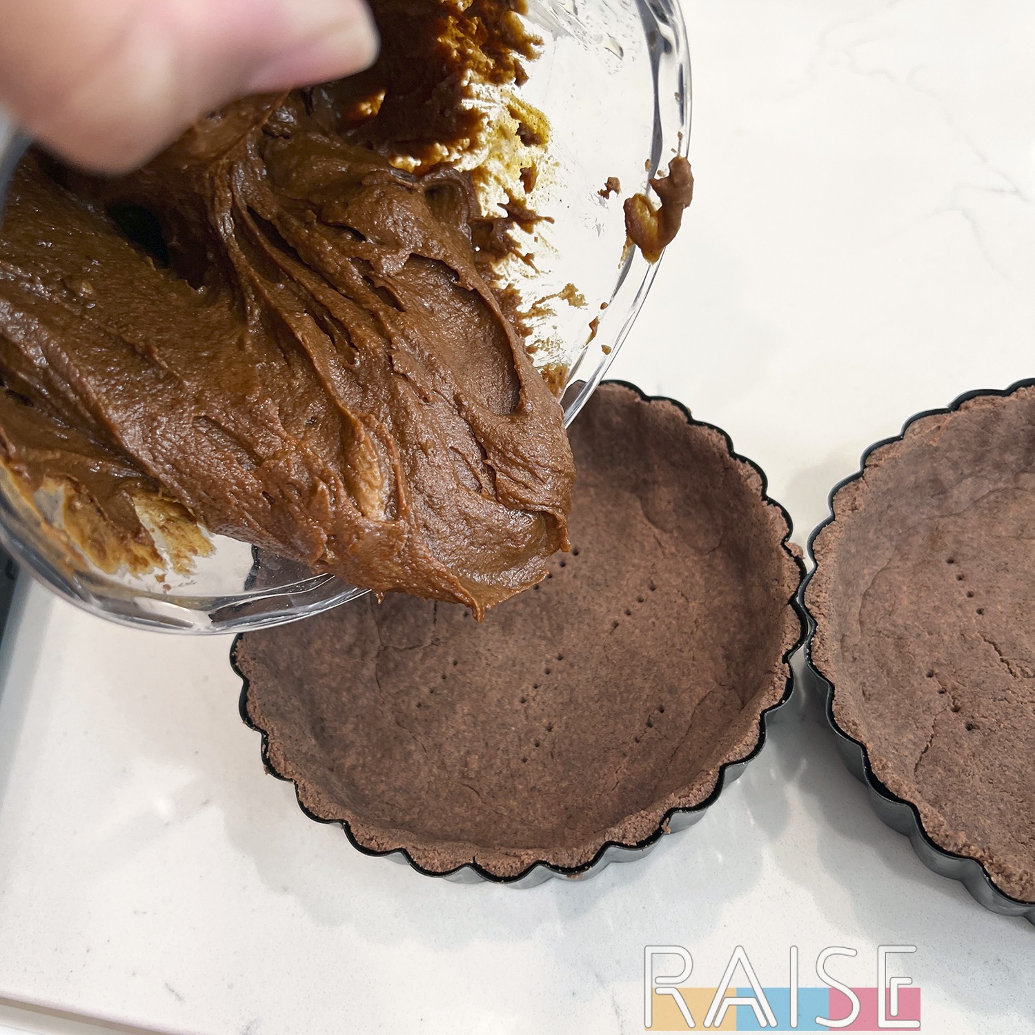 Pouring Filling Into Baked Chocolate Tart Shells