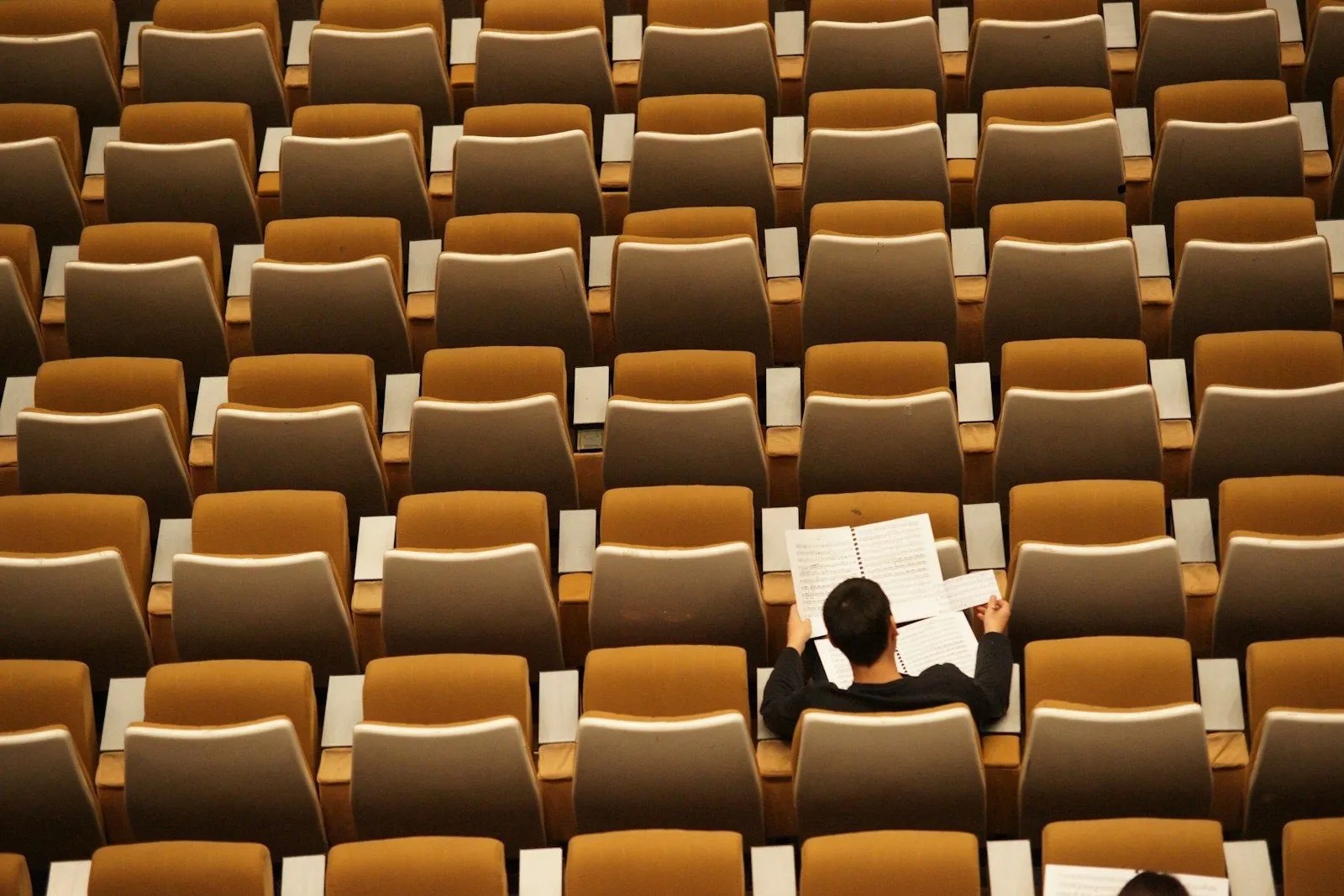 Person liest in einem leeren Hörsaal