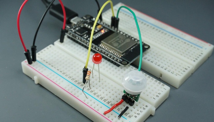 ESP32 on a breadboard connected to an LED and a PIR motion sensor