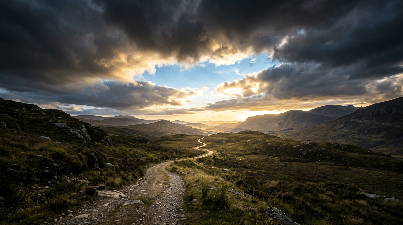 Winding rocky trail through highlands beneath dramatic sunset clouds