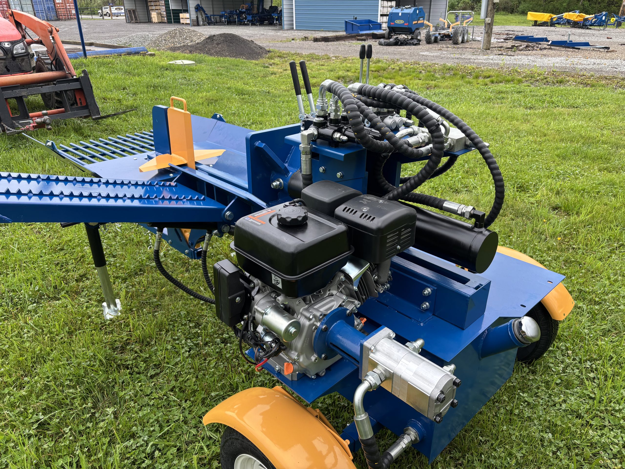 Heavy-duty blue wood chipper with engine and hydraulic hoses.