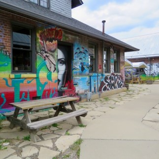 Outdoor dining in the arts district beneath creepy murals