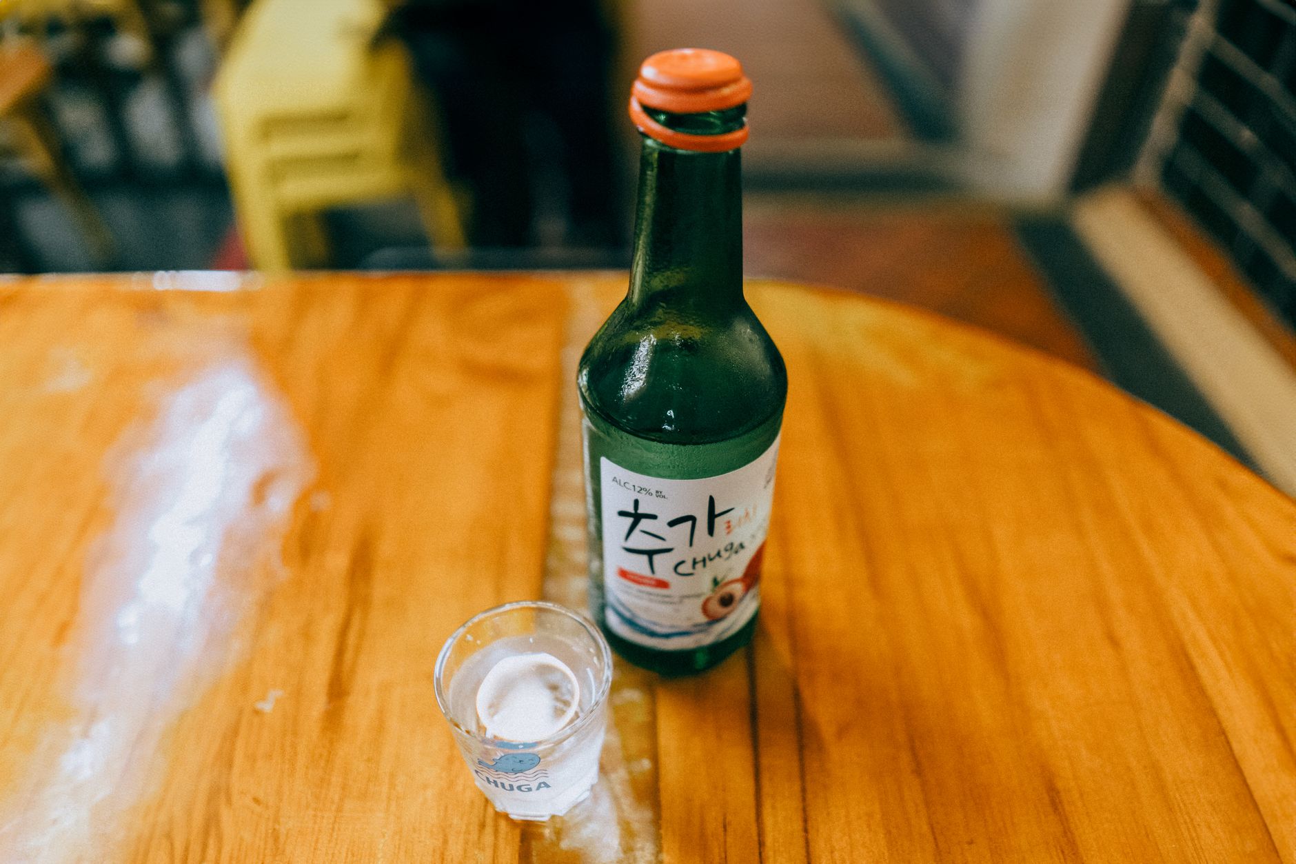 Two hands pouring soju for someone holding their glass with both hands, the standard Korean drinking etiquette