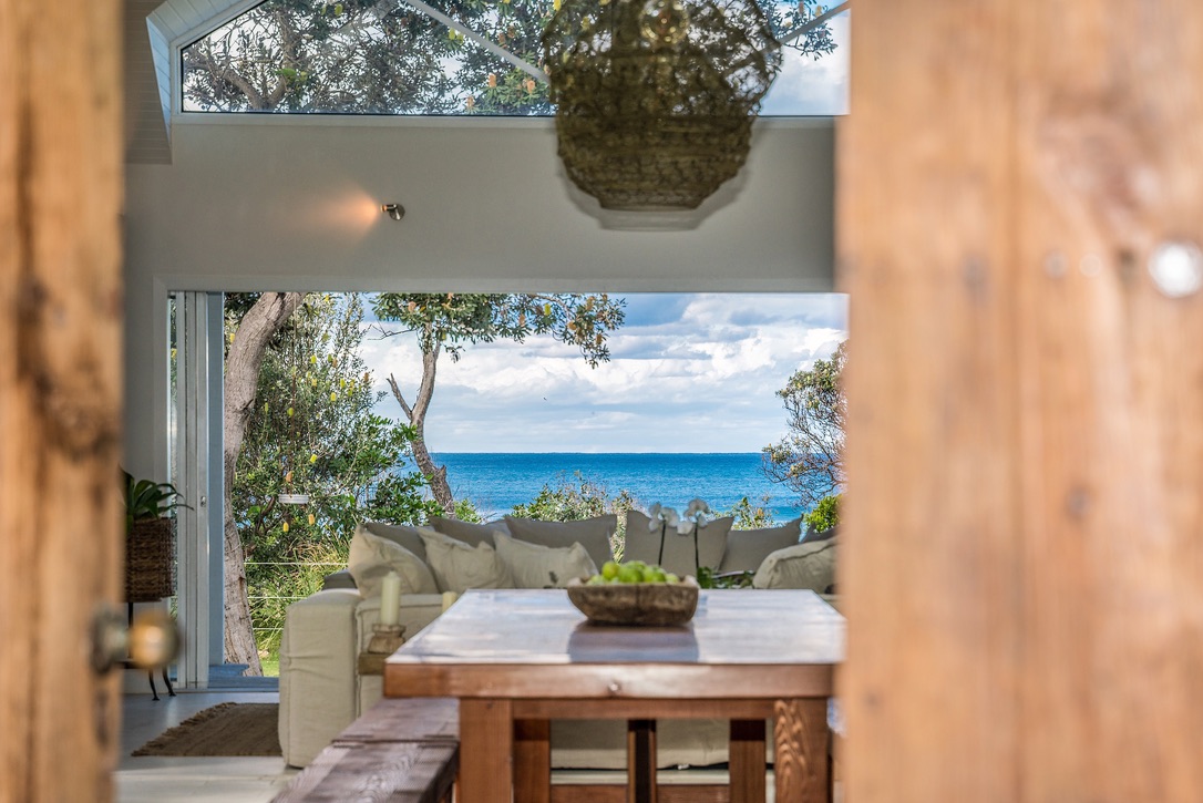 Ocean view from modern coastal living room with timber dining table