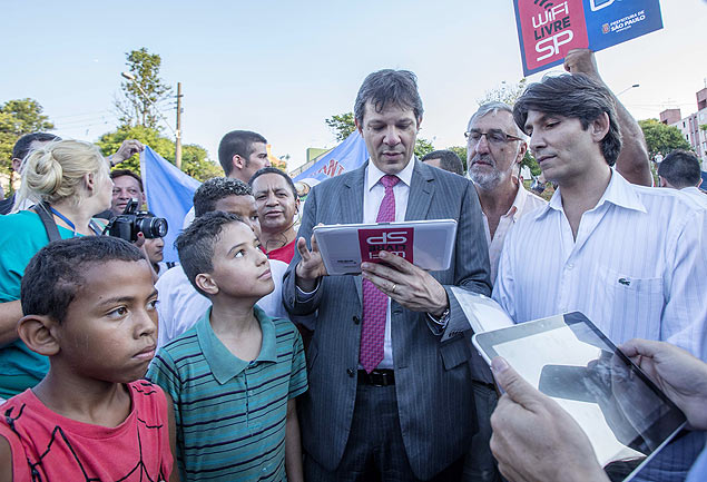 O prefeito Fernando Haddad (PT) testa um dos wi-fi na cidade; atrás, a placa que identifica as redes