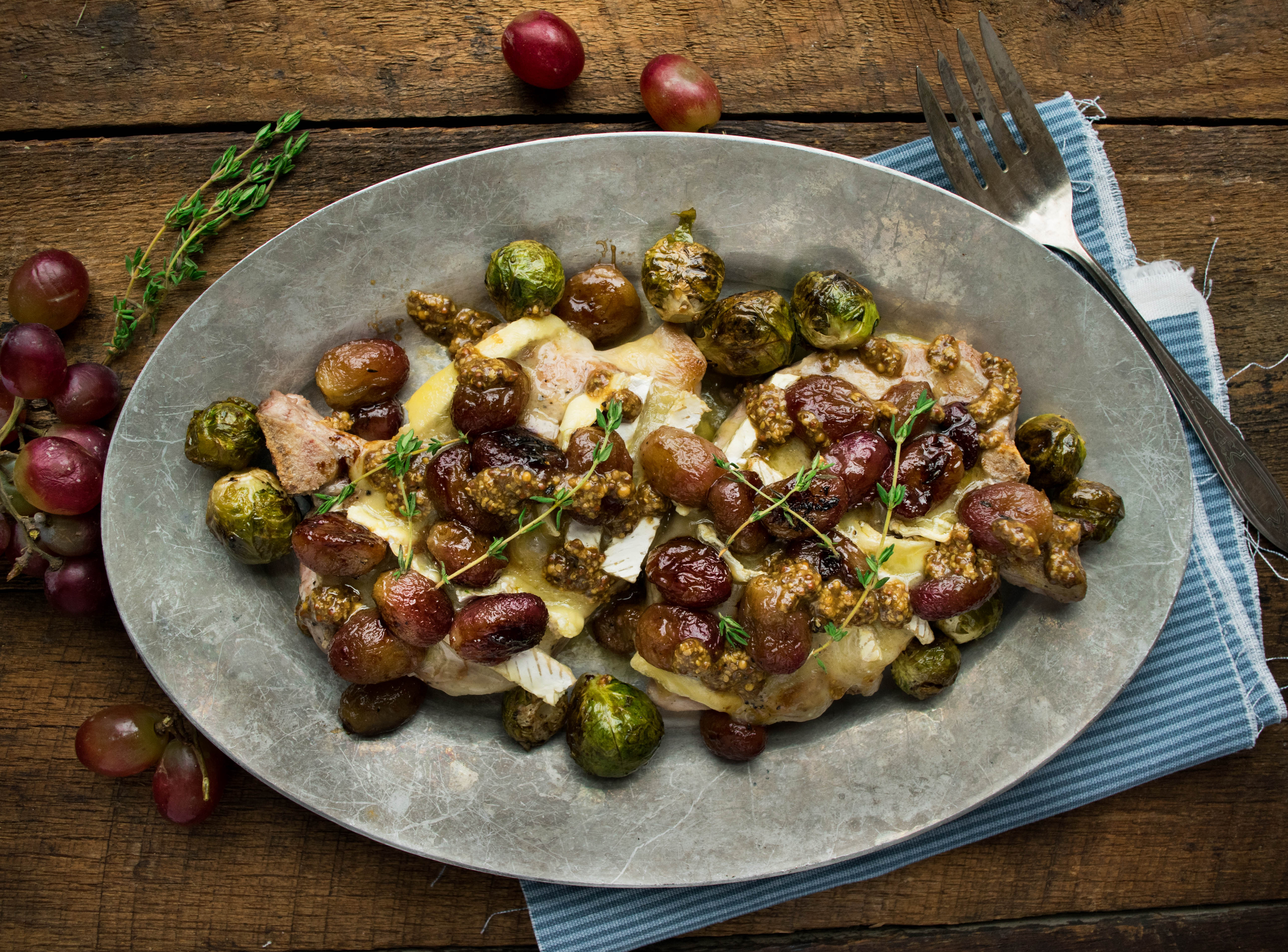 Brie Smothered Pork Chops with Roasted Grapes and Grainy Mustard Pan Sauce