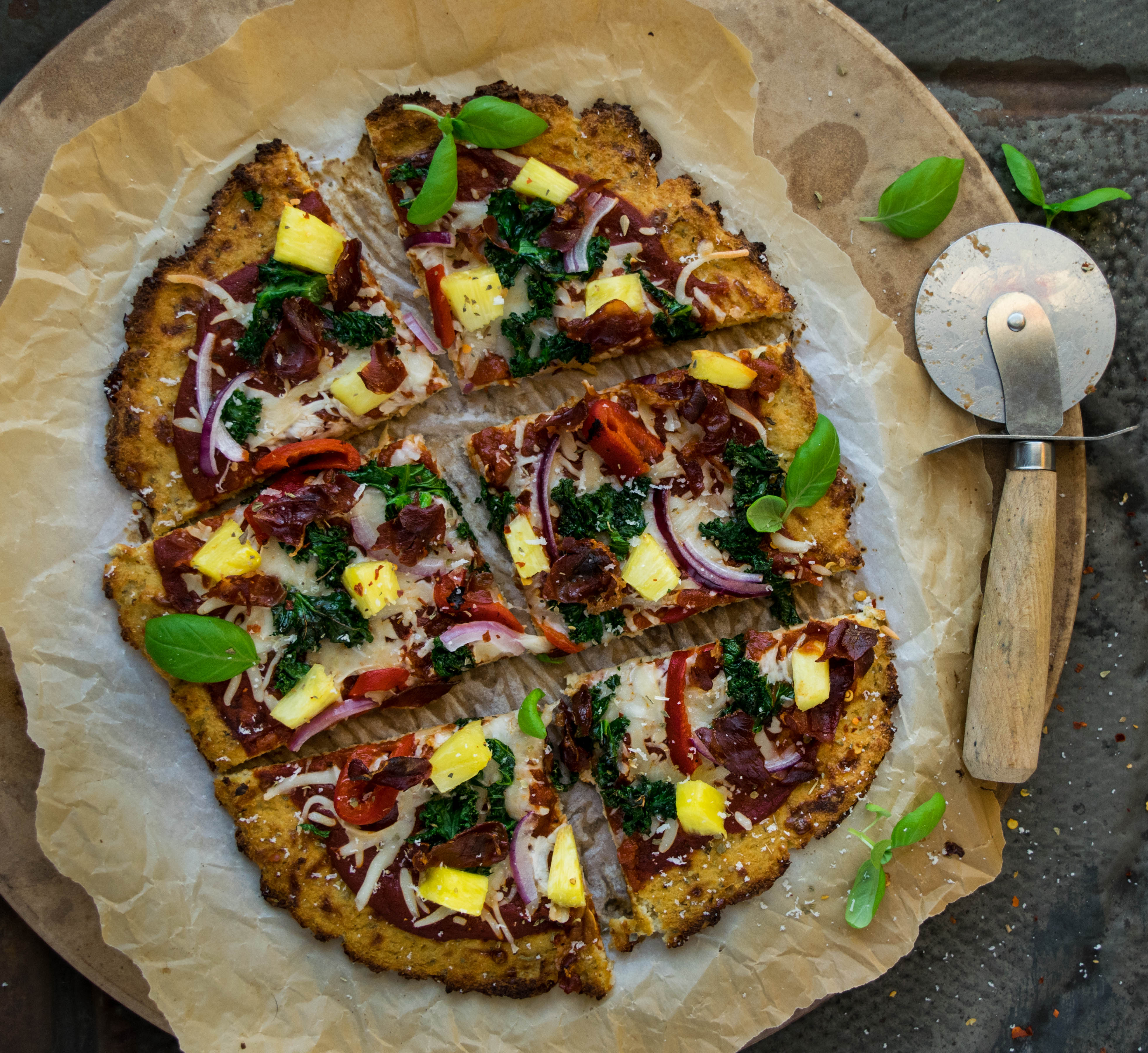 Cauliflower Crust Hawaiian Pizza with Crispy Prosciutto, Kale, and Roasted Red Peppers