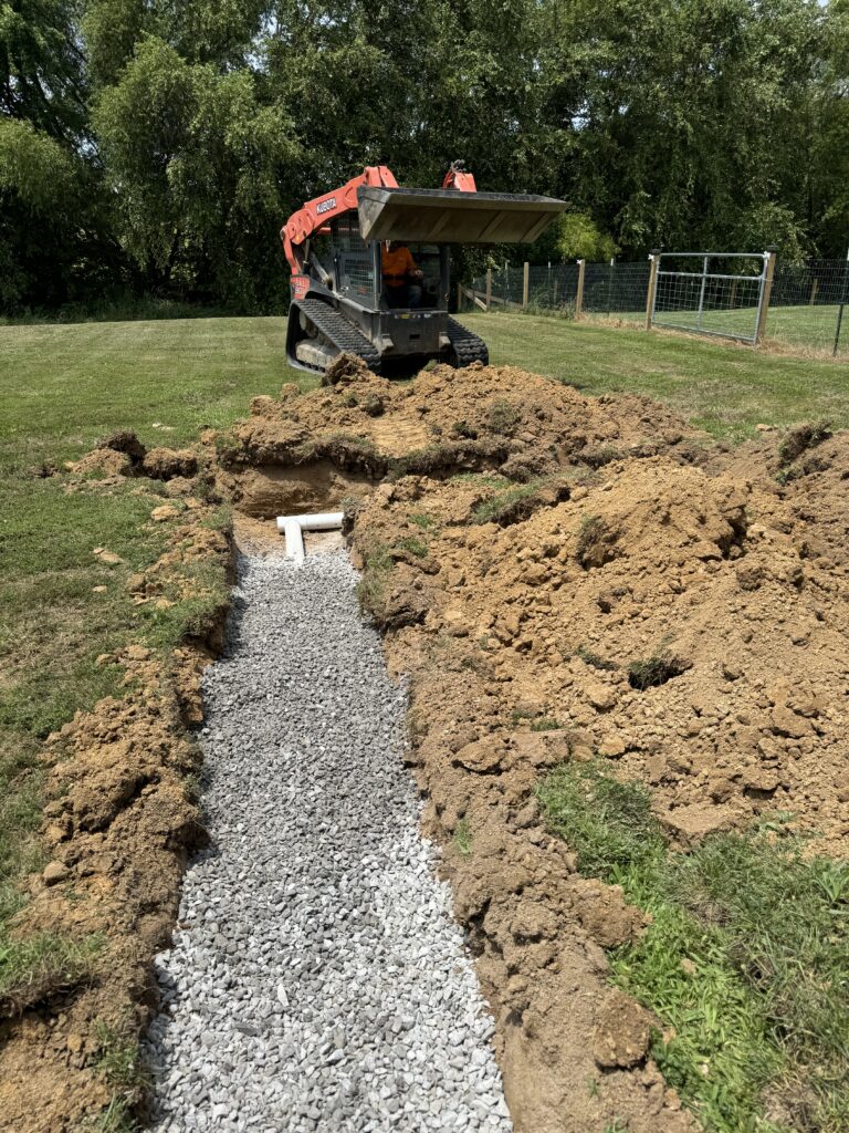 4" drainage tile with 1" clean gravel laid around to improve yard drainage and erosion control