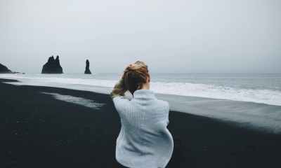 woman wearing sweater standing in front of beach