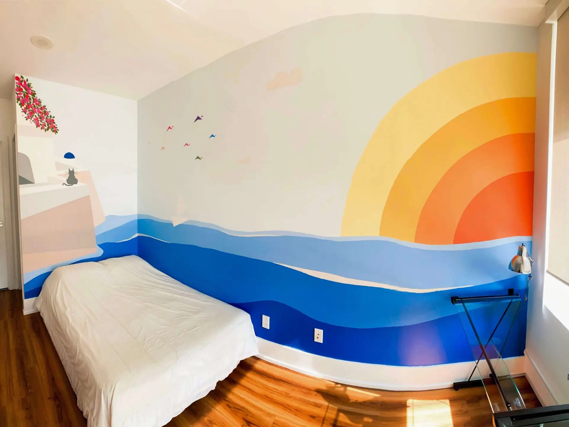 Corner wall mural depicting a sunset seen from a Greek island.