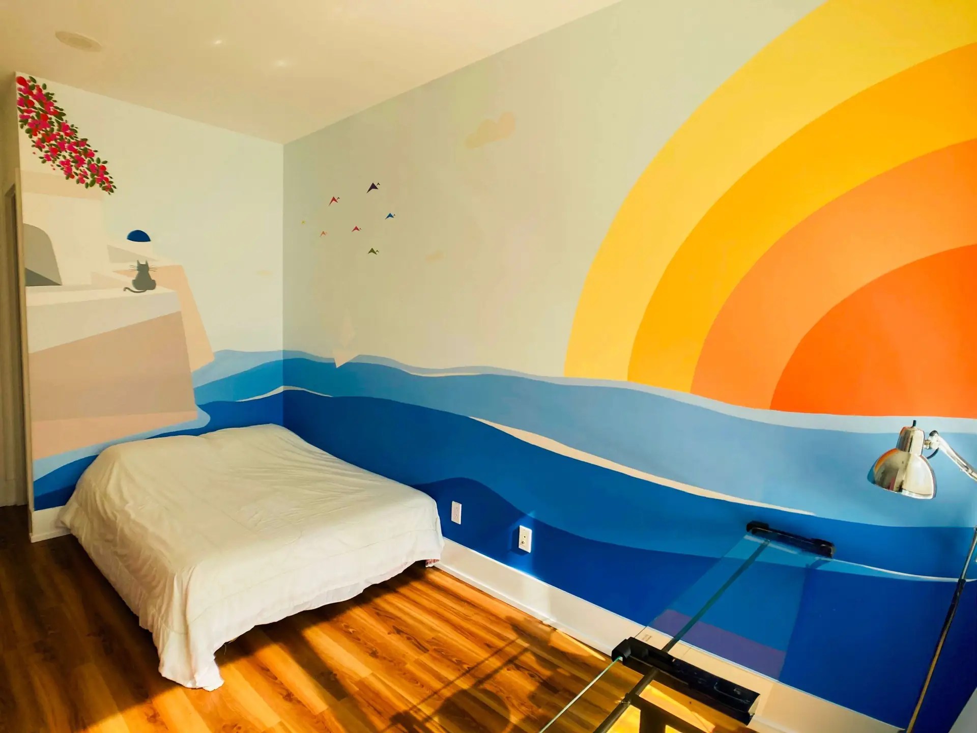 Corner wall mural depicting a sunset seen from a Greek island.