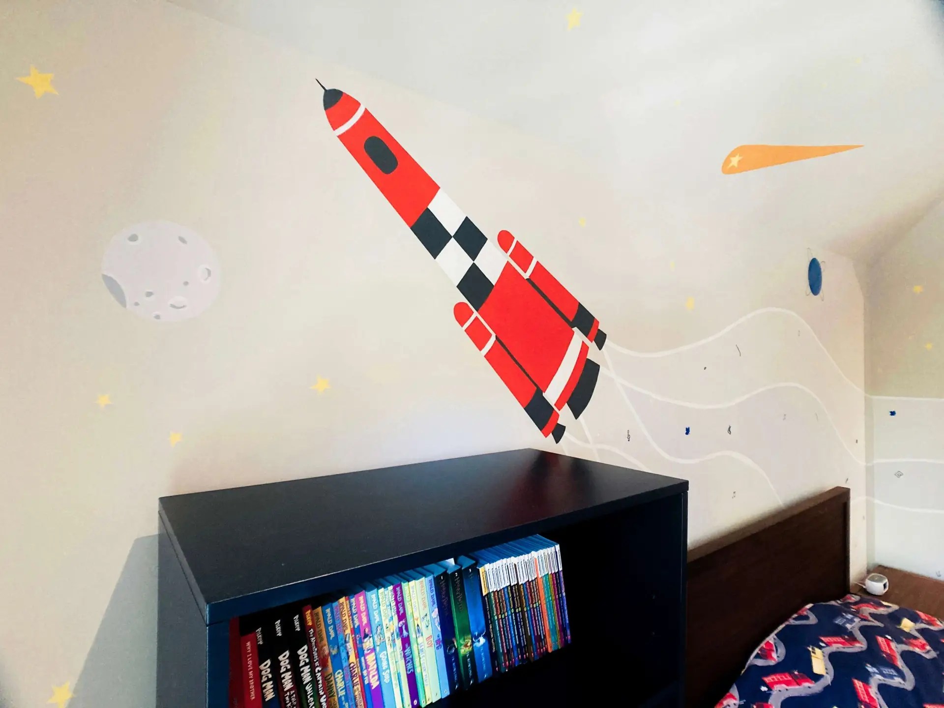 Closeup showing the rocket in detail, the moon, stars, comet and a planet.