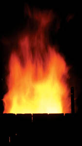 Wood-firing pottery involves a lot of steps. The kiln’s chimney spews flames, which flare to four feet high as the kiln is stoked.