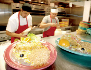 Cooks Manuel Senteno, left, and Arturo Ruiz busily prepare food for the lunch rush at La Posada.