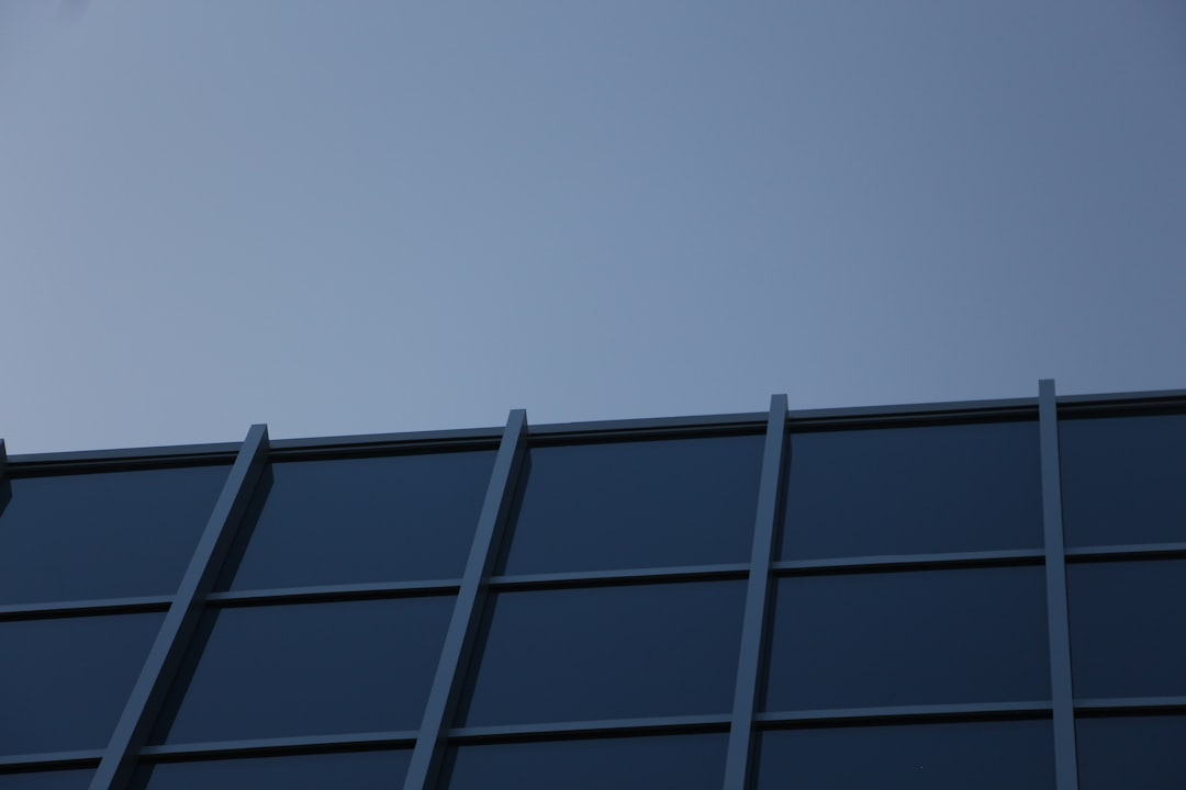 an airplane is flying in the sky over a building