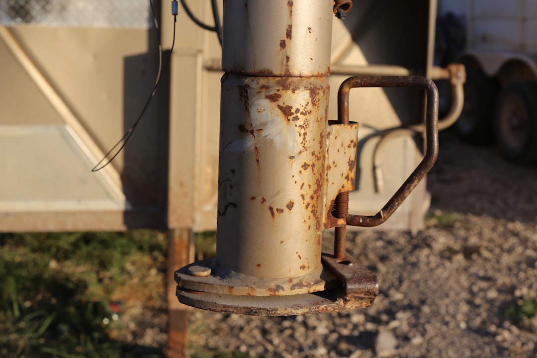 a rusted metal pole next to a dump truck