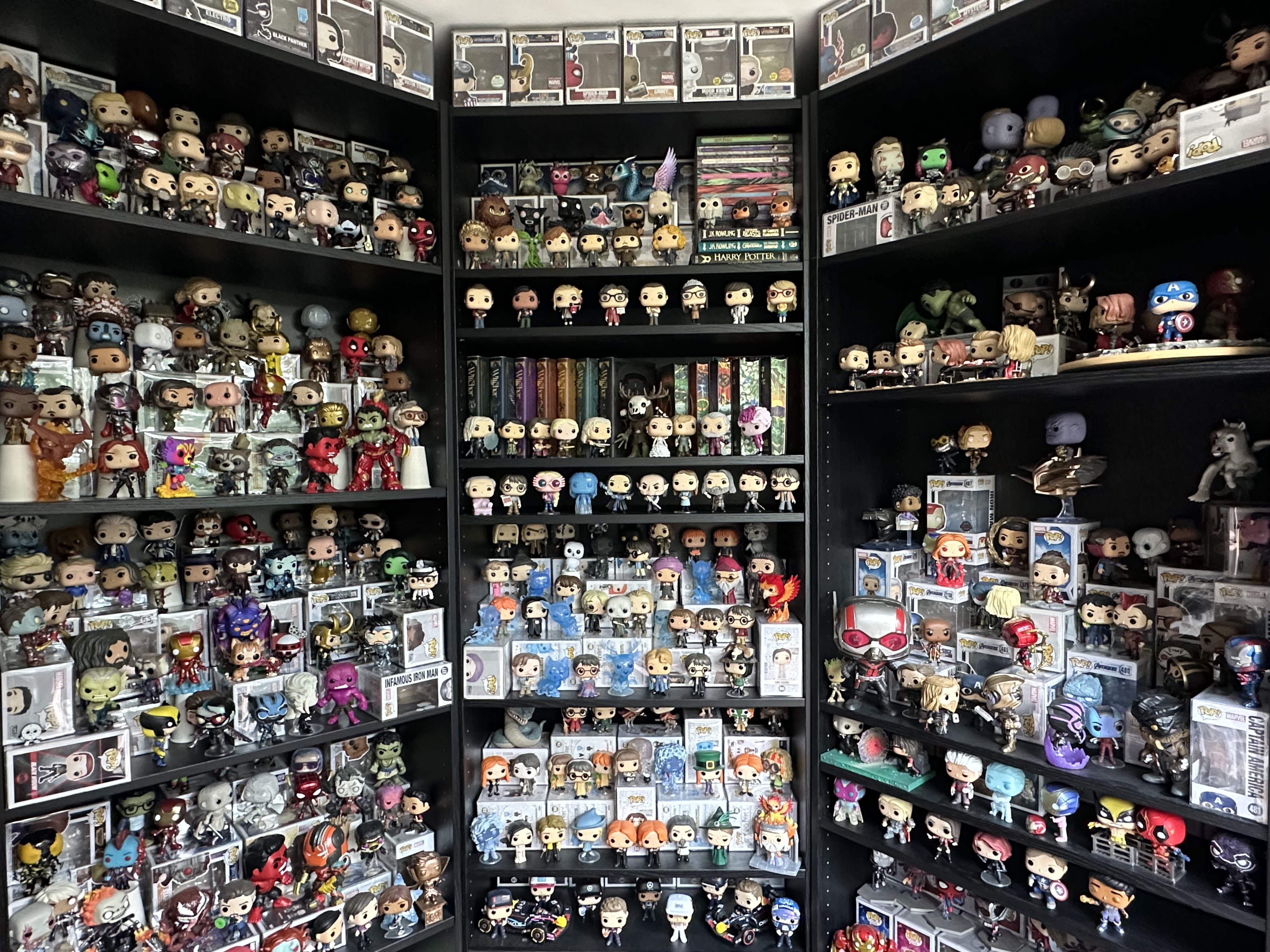 Large Funko Pop collection of over 800 figures displayed in black wall shelves, featuring Marvel, Harry Potter, and Disney Pops