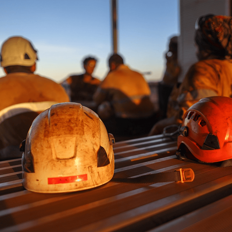 Miners at work with hats on a table