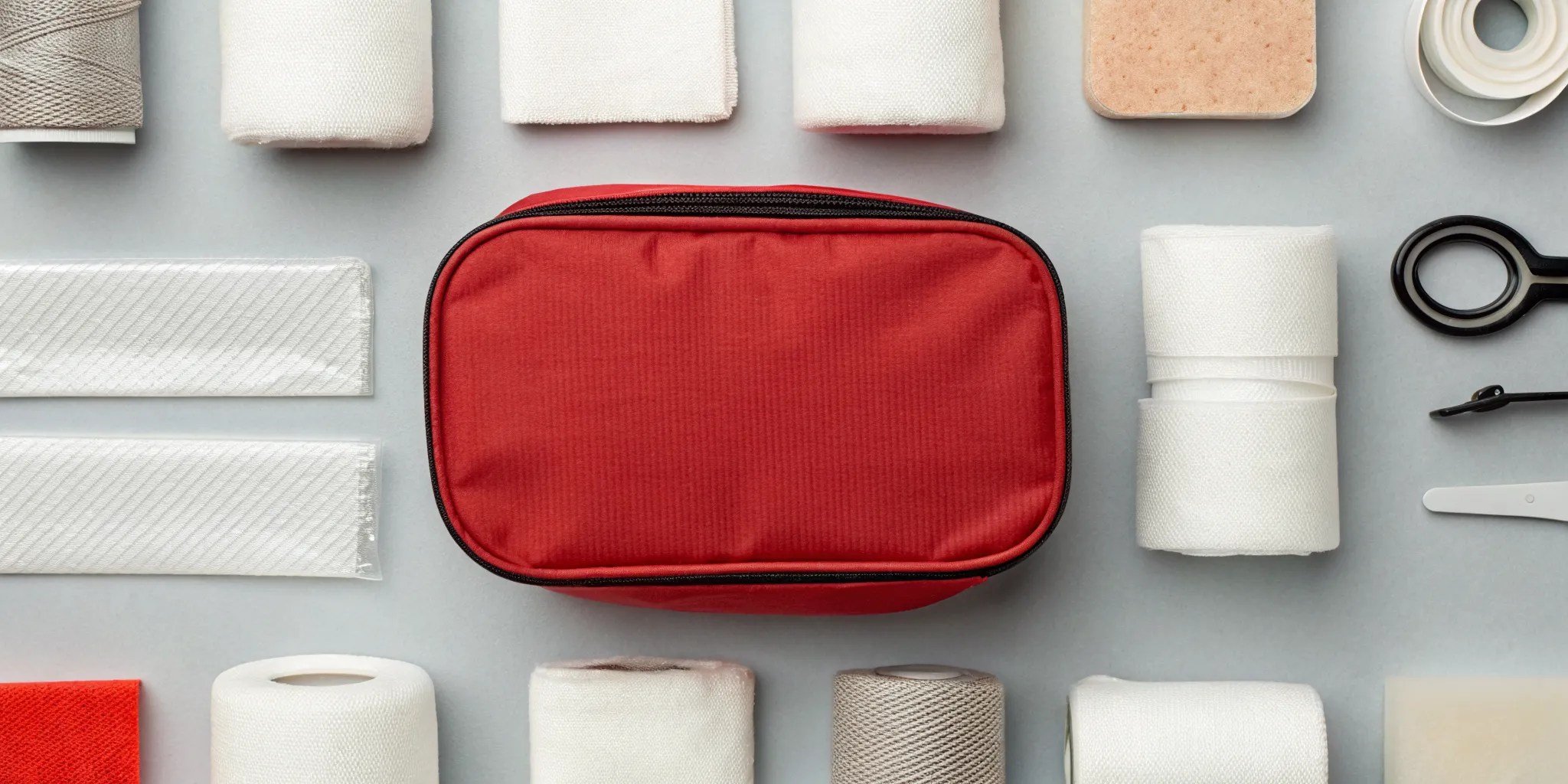 Stop the bleed kit with essential supplies including gauze, bandages, medical tape, and scissors.