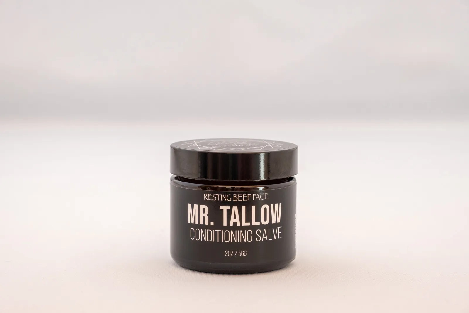 Amber glass jar of Mr. Tallow Conditioning Salve by Resting Beef Face displayed on a clean white background, featuring a black label with minimalist branding.