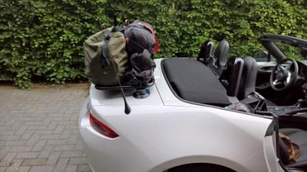 mazda mx5 nd blanc avec un porte-bagages équipé transportant une tente et du matériel de camping
