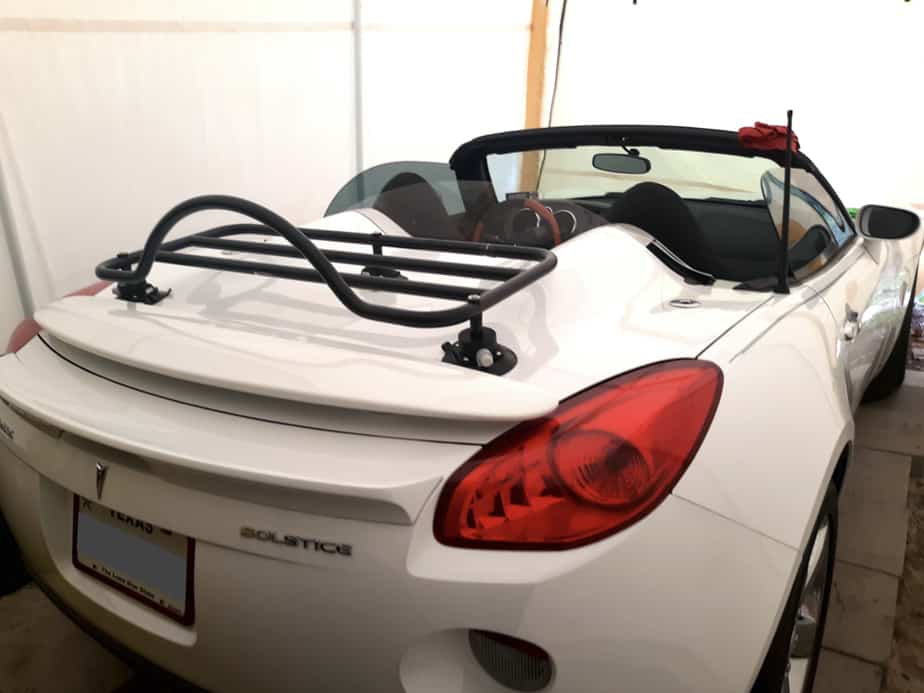 white pontiac solstice in a garage with a revo-rack black luggage rack fitted