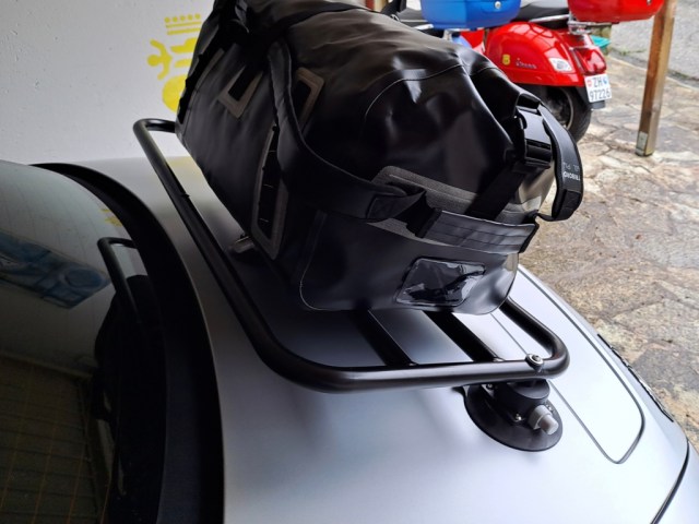 Mercedes AMG GTC argentée dans un garage avec un porte-bagages Revo Rack et un sac noir