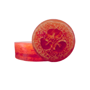Two round, transparent burgandy‑colored soap bars with a natural loofah slice visible inside. The loofah’s fibrous texture shows through the clear base, creating a warm, autumn look.