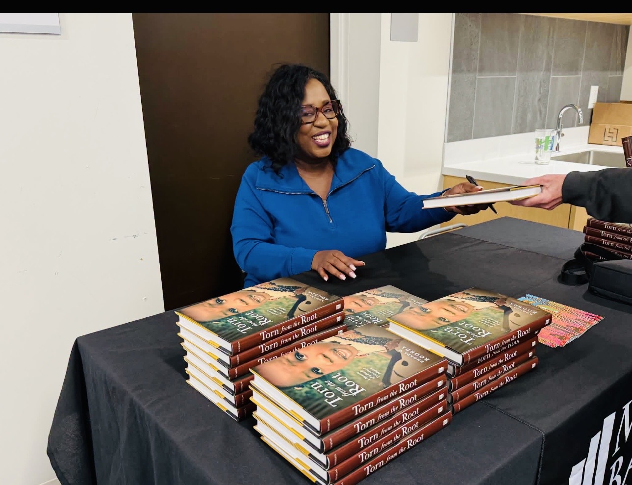 Rhonda M. Roorda signing copies of Torn from the Root