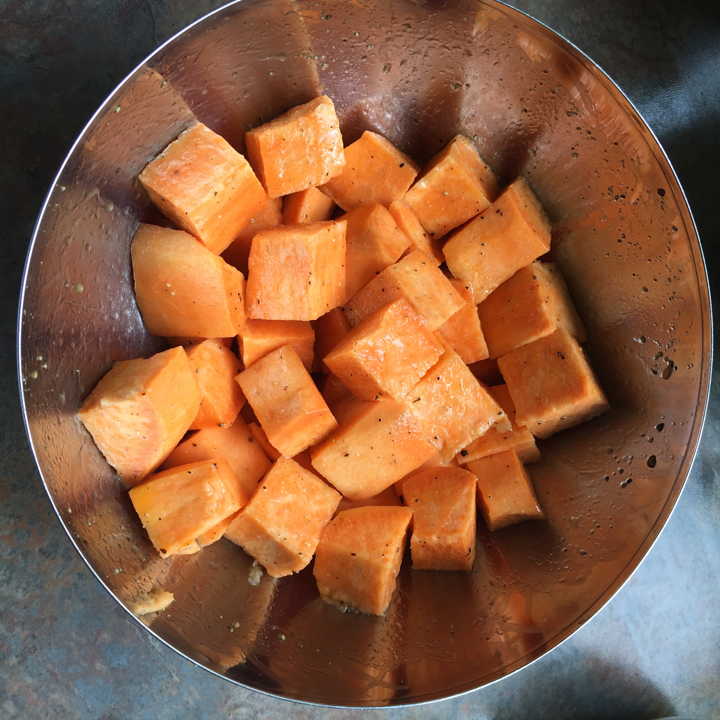 Sweet potatoes coated with olive oil and seasoned with salt and pepper