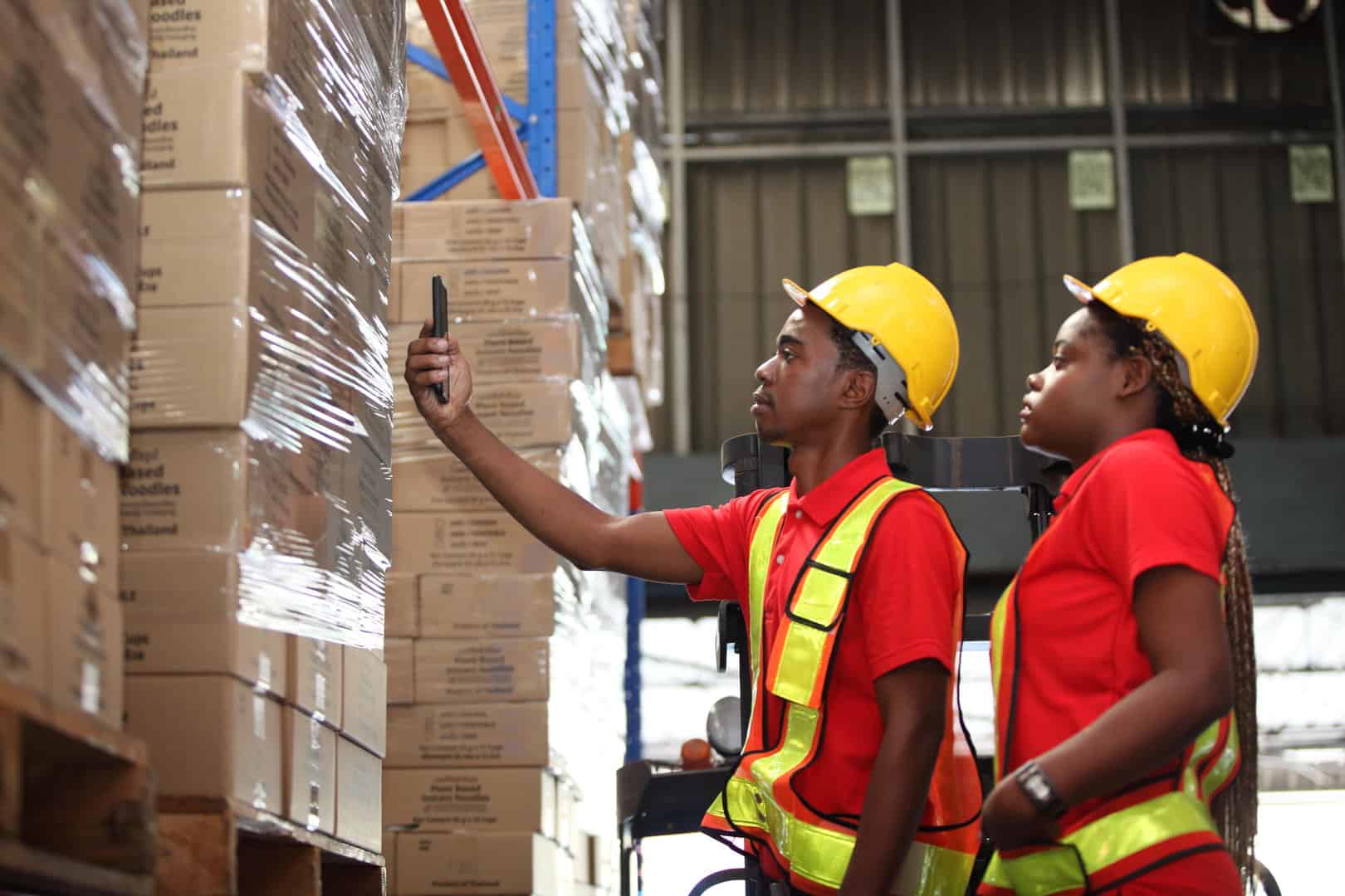 Portrait of worker in warehouse , they happy and working at The Warehouse. Storehouse area, Shipment. warehouse worker unloading pallet goods in warehouse