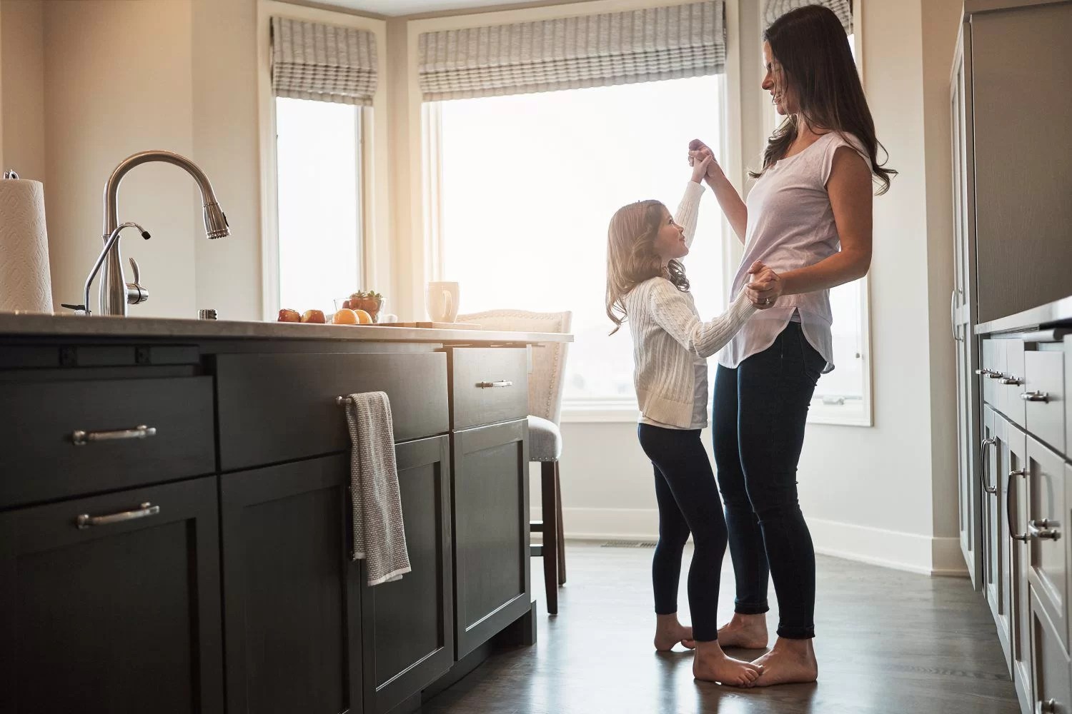 Mother daughter dancing in kitchen