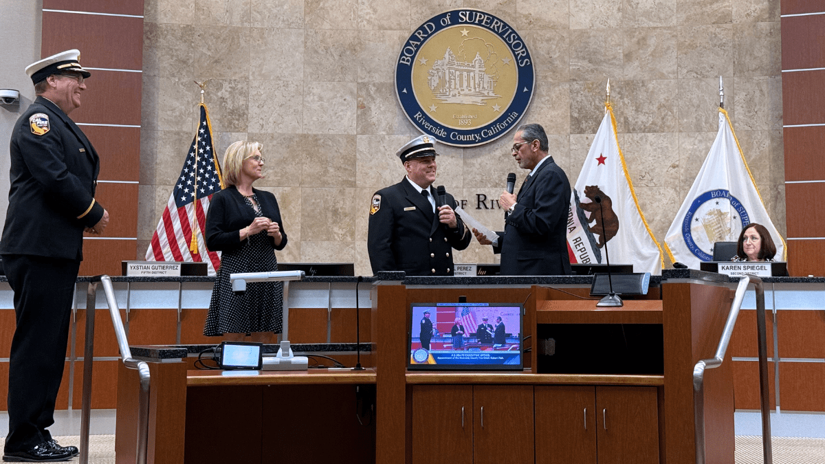 Supervisor V. Manuel Perez administers the oath of office to newly appointed Riverside County Fire Chief Robert Fish as his wife and retiring Fire Chief Bill Weiser look on.