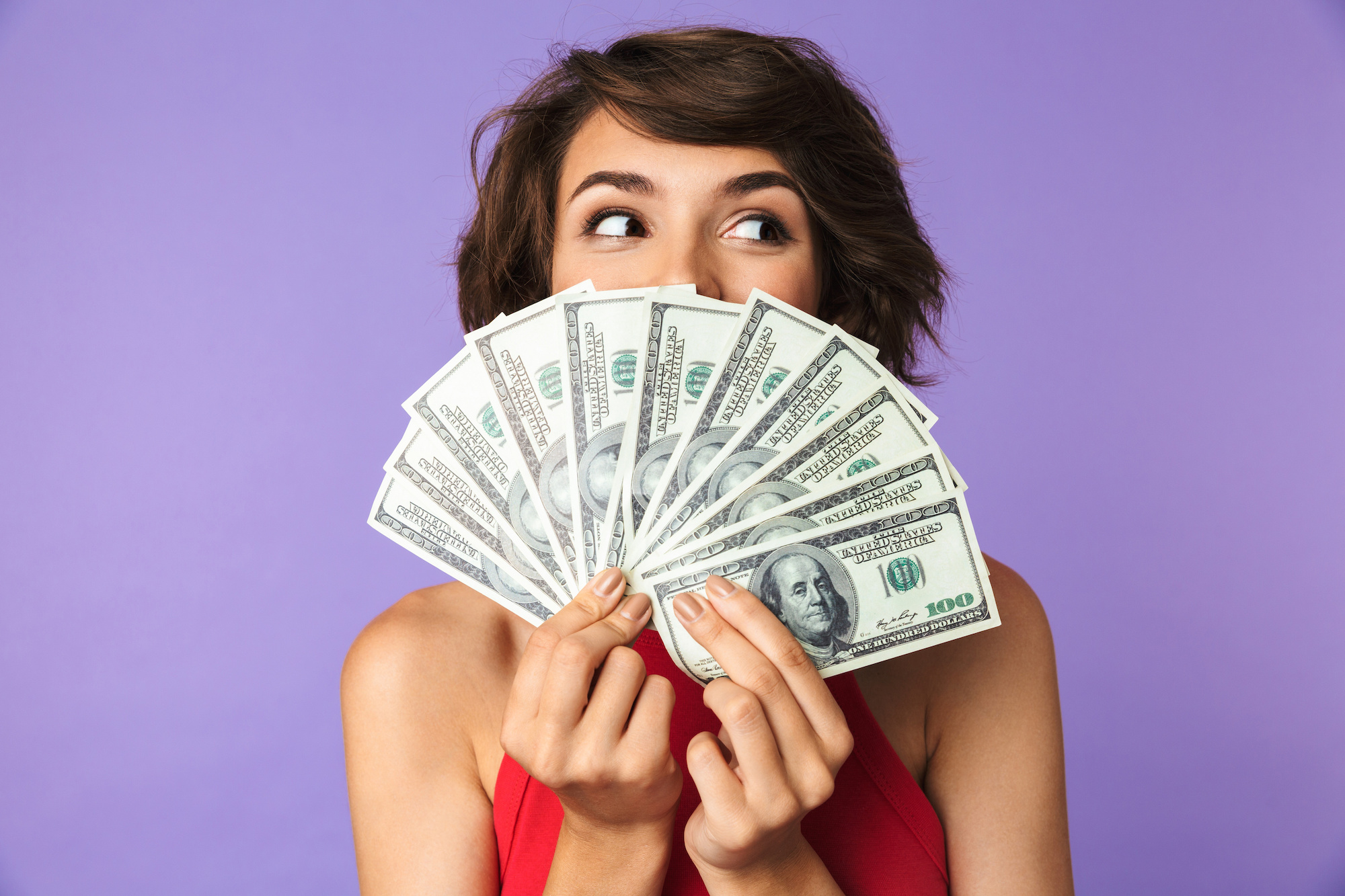 Happy Pretty brunette woman covering her face with money