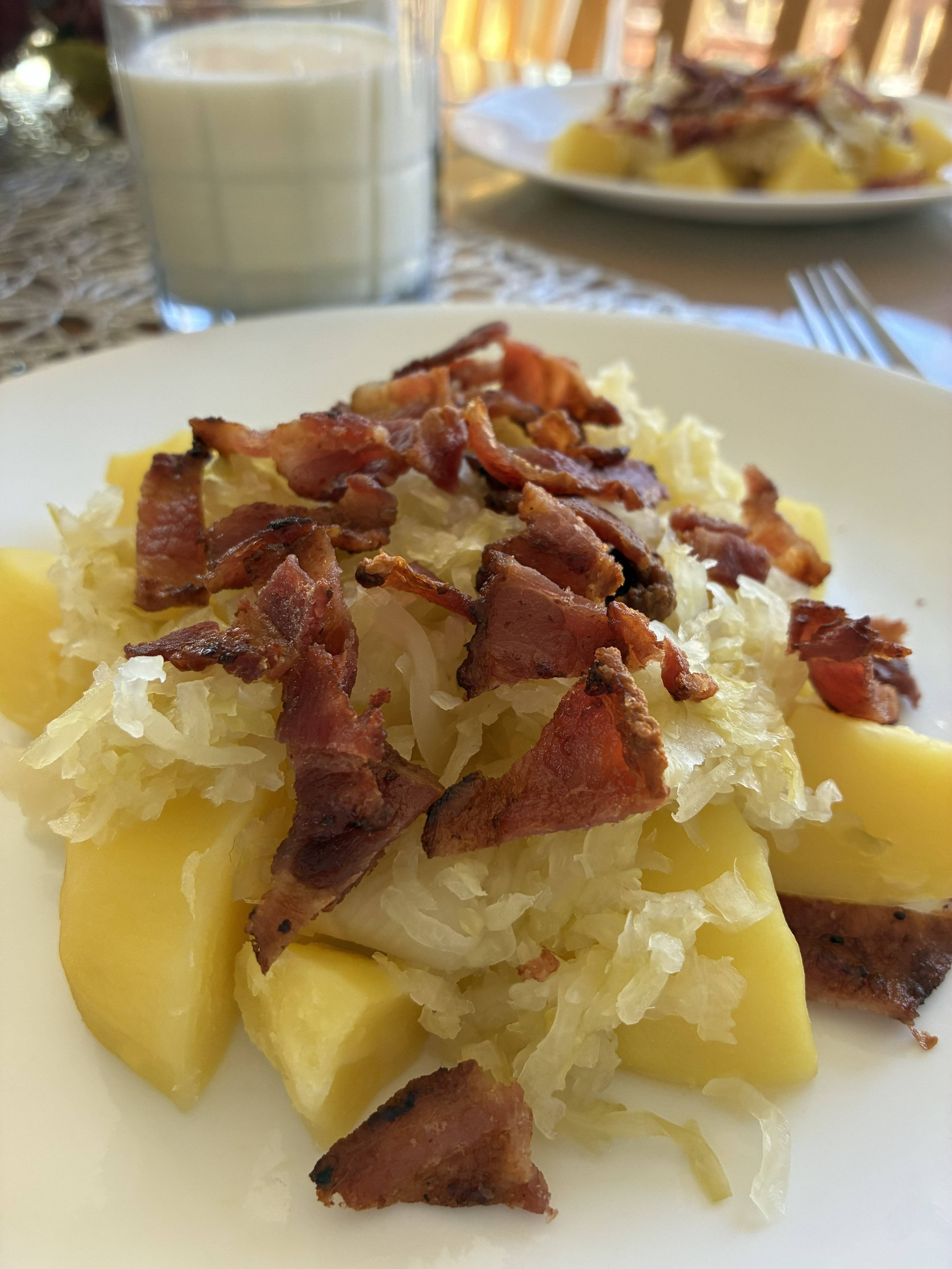 Boiled Potatoes with Raw Sauerkraut and Crispy Bacon on the table.