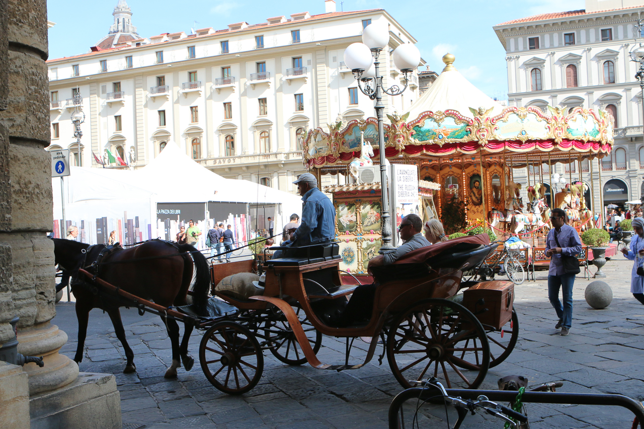 The Piazza Della Republica, in modern center of Florence, is like a circus atmosphere with Merry-Go-Round, a book bazaar, carriage rides, and more.