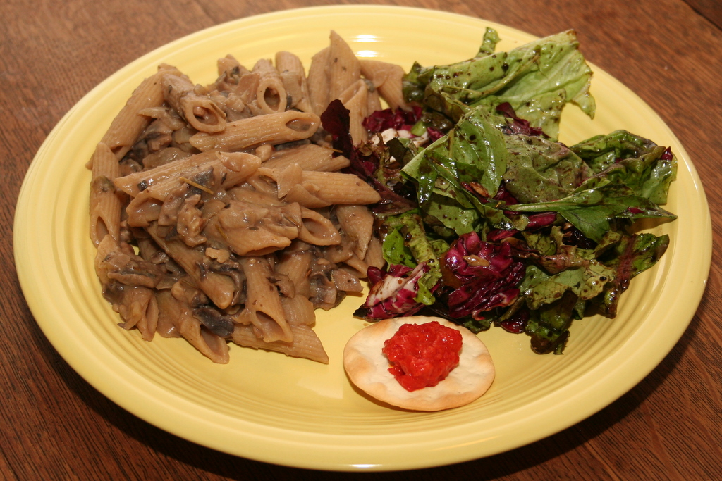 Penne with caramelized onion, mushroom and white bean sauce, accompanied by mixed green salad and cracker with red pepper eggplant spread