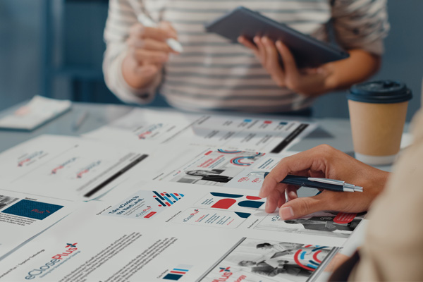 Branding agency designers reviewing branding examples and style guide for software product company.