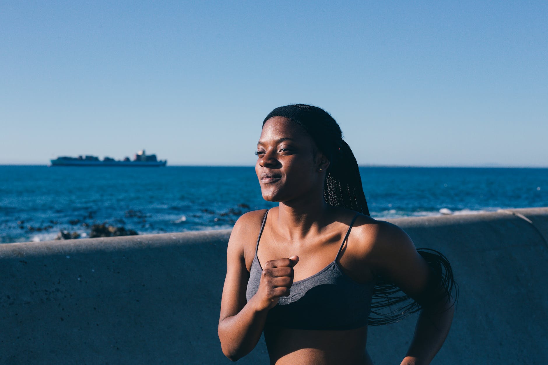 woman in active wear jogging by the bay