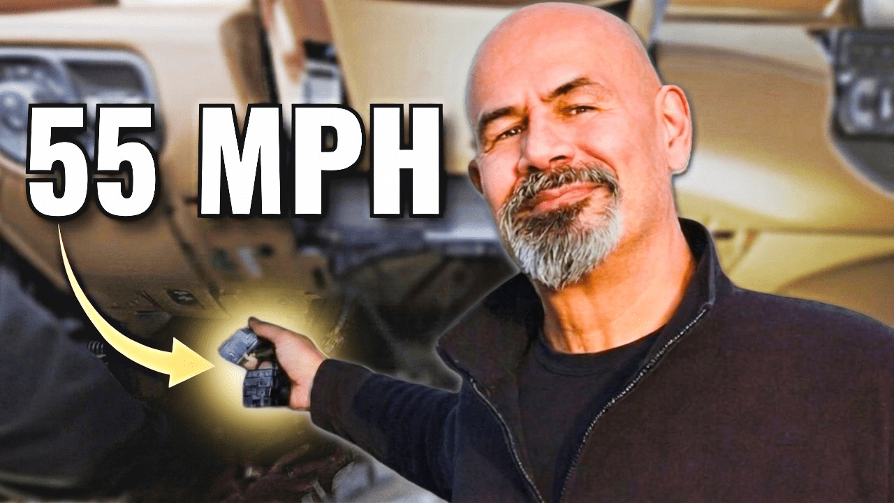 Matt pointing to the OBD bypass cable under the RAM dash — 55 MPH DEF warning