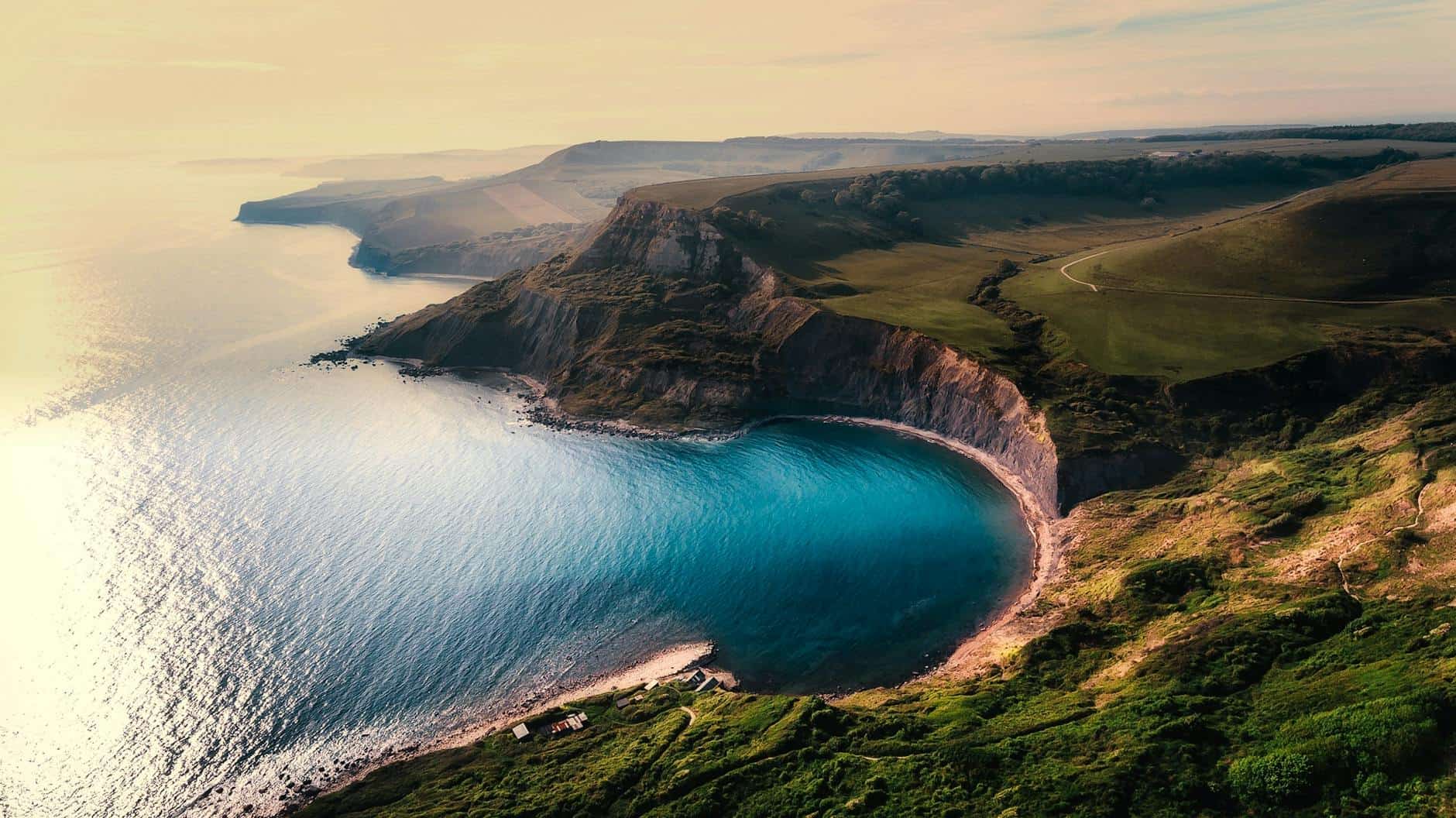 colina verde cerca de una masa de agua